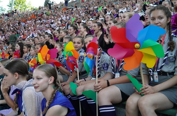 Publiczność na koncercie galowym na kieleckiej Kadzielni, na pierwszy planie grupa harcerek trzymająca kolorowe wiatraki