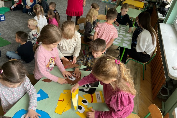 Dzieci układające ekologiczne puzzle przy stoliku