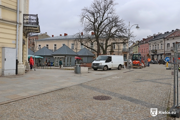 Fragment Rynku, widok w stronę pl. św. Tekli, na drugim planie zaparkowany biały samochód i kwiaciarnie