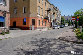 ulica Silniczna, widok od ul. Pelca, po lewej stronie zaparkowane samochody i budynki.