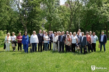 zdjęcie przedstawia grupę uczestników Świętokrzyskiego Spotkania Transplantologicznego podczas spaceru w Dolinie Silnicy. Uczestnicy stoją w grupie na trawie, za nimi drzewa