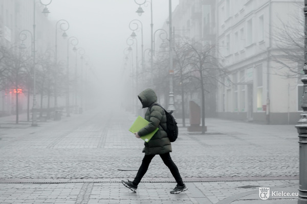 osoba idąca zamgloną ul. Sienkiewicza